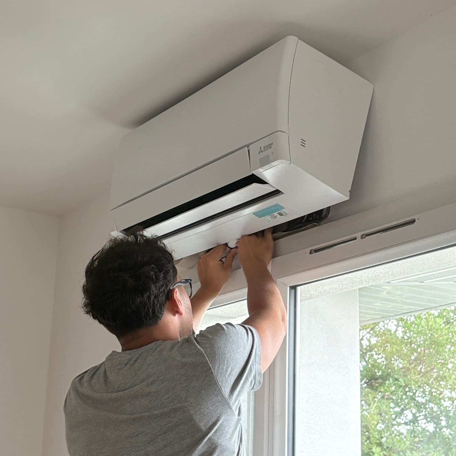 Technicien BP Maintenance installant une unité intérieure Mitsubishi Electric chez un client à Morancé